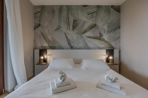 a bedroom with a white bed with towels on it at Residence San Michele in Costermano sul Garda