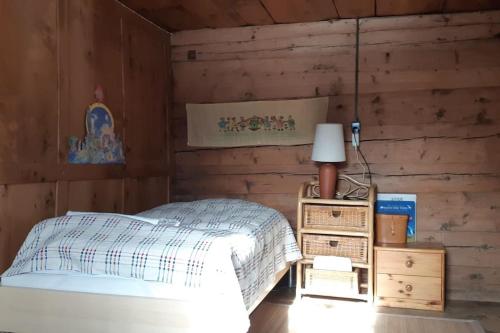 a bedroom with a bed and a wooden wall at Absolut ruhige Aussichtslage in uraltem Holzhaus in Braunwald