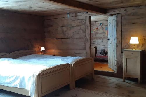 a bedroom with a bed in a room with wooden walls at Absolut ruhige Aussichtslage in uraltem Holzhaus in Braunwald