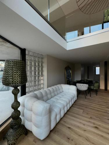 - un salon avec un grand canapé blanc et une lampe dans l'établissement Nice Living Cannes Plage, à Cannes