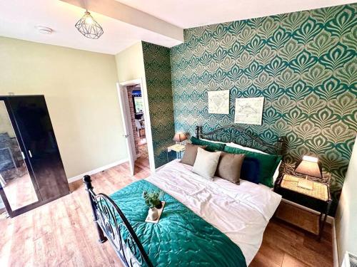 a bedroom with a bed with a green wall at Exec 2 bed lodge in rural Wales with Cymru Holidays in Pontnewydd