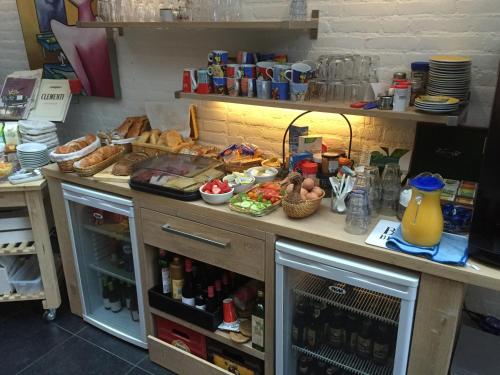 eine Küche mit einer Theke mit Speisen und Getränken in der Unterkunft B&B - Pension Perruque in Koudum