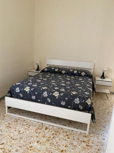 a bedroom with a bed with a black and white comforter at B&B Pompeii Airfield in Poggiomarino