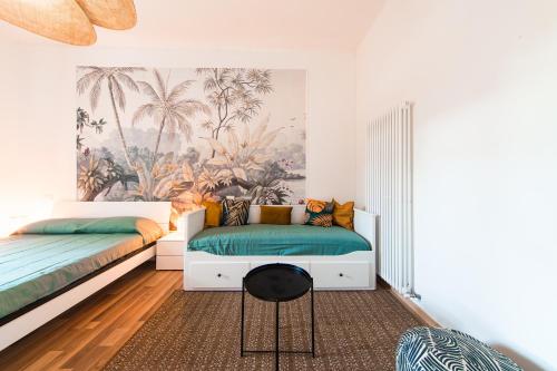 a bedroom with two beds and a mural of palm trees at Becky in Bologna