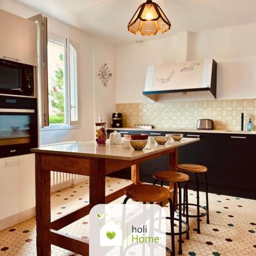 - une cuisine avec une table et quelques tabourets dans l'établissement H12 Charmante maison de campagne, à Balazé