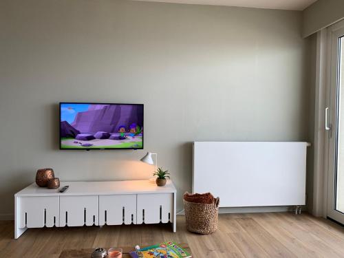 a living room with a tv on a white wall at Appartement Admare Middelkerke in Middelkerke