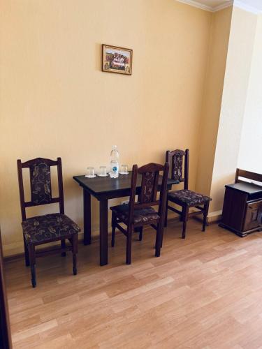 a dining room with a table and four chairs at Etna Hotel in Lviv