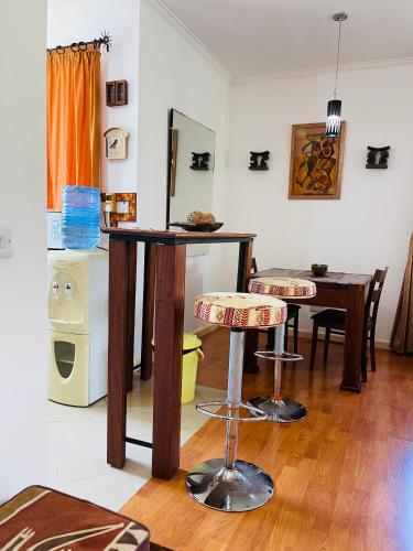 a living room with a table and two stools at Seaside Beach Bungalow in Dar es Salaam