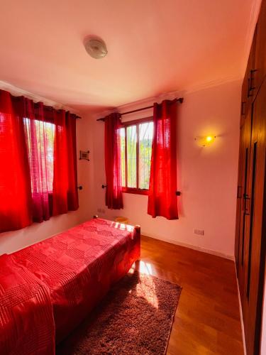 a bedroom with a red bed and red curtains at Seaside Beach Bungalow in Dar es Salaam