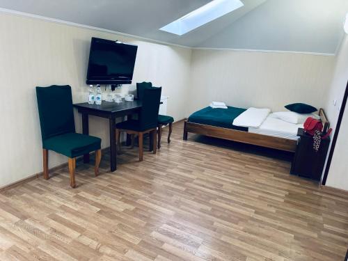 a room with a bed and a table and chairs at Etna Hotel in Lviv