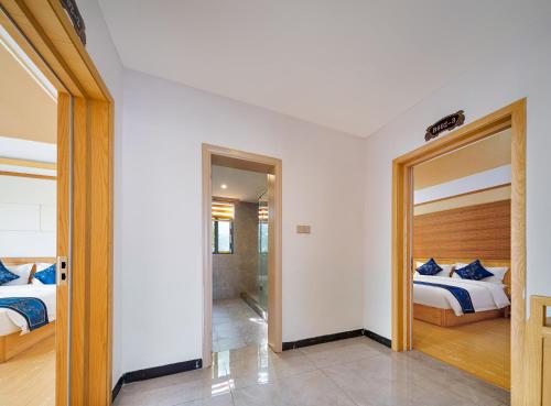 a bedroom with two beds and a doorway to a room at Zhangjiajie DreamWay Hotel - Free pick up service in Zhangjiajie