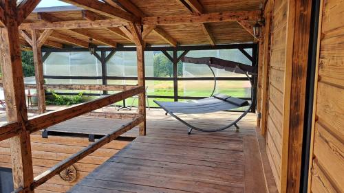 a porch with a hammock in a wooden cabin at Chalupa Konírna in Rumburk
