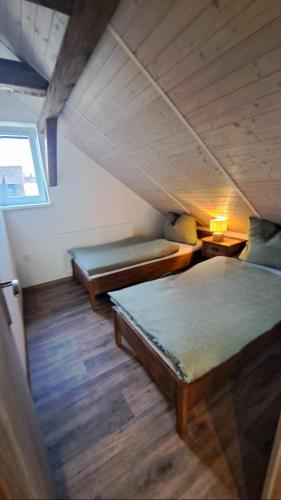a attic room with two beds and a window at Chalupa Konírna in Rumburk