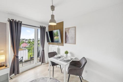 Un comedor con mesa y sillas y una ventana. en Go2Cozy - Study & Work Apartments - WIFI - Kitchen, en Kaiserslautern