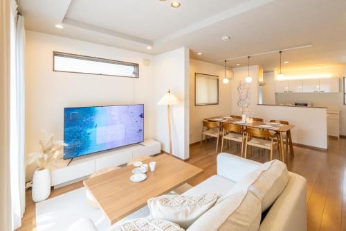 a living room with a couch and a tv and a table at It' ta de ChouChou - Self Check-In Only in Osaka