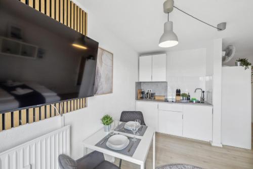 Una sala de estar con una mesa y una cocina. en Go2Cozy - Study & Work Apartments - WIFI - Kitchen, en Kaiserslautern