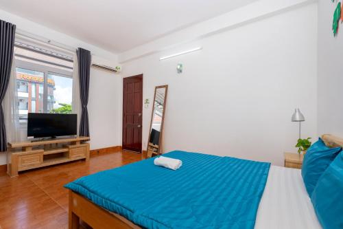 a bedroom with a bed and a flat screen tv at Ann Homestay Vũng Tàu in Vung Tau