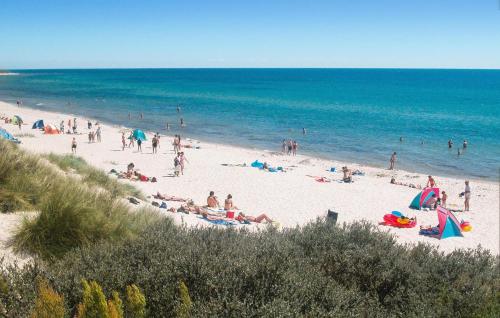 eine Gruppe von Menschen an einem Strand in der Nähe des Ozeans in der Unterkunft Holiday Home Malurtvej Aakirkeby Iv in Vester Sømarken
