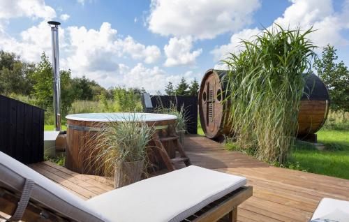 a wooden deck with a table and some tall grass at Holiday Home Ballesvej in Øster Assels