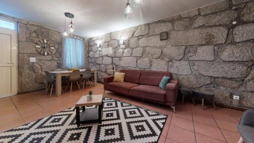 a living room with a couch and a stone wall at Vivenda Center Porto in Porto