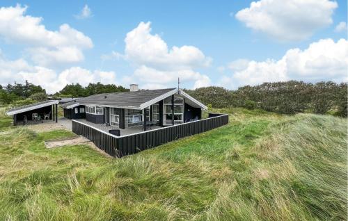 a house sitting on top of a grass field at Stunning Home In Henne With Sauna in Henne Strand