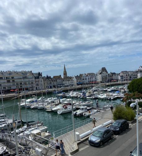 une marina avec des bateaux dans l'eau et des bâtiments dans l'établissement Studio La Baule vue port du Pouliguen, à La Baule
