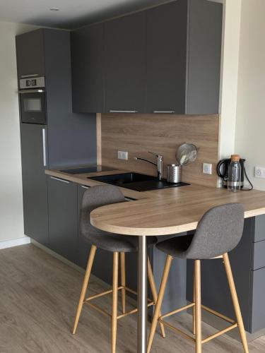 une cuisine avec une table en bois et deux chaises dans l'établissement Studio La Baule vue port du Pouliguen, à La Baule