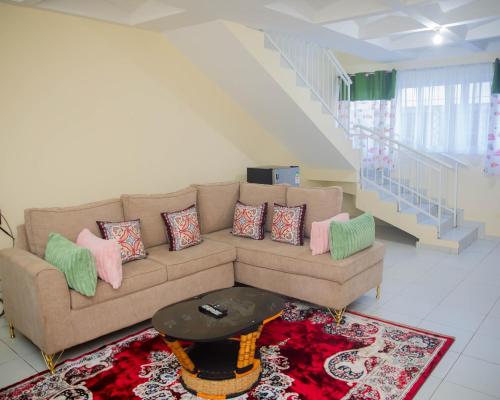 a living room with a couch and a table at Serena Road Villa B in Shanzu