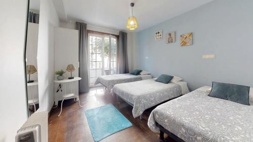 a bedroom with two beds and a window at Vivenda Center Porto in Porto