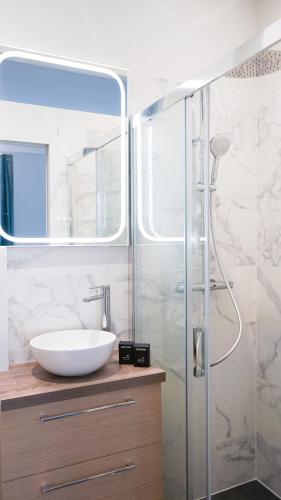 une salle de bain avec un lavabo et une douche en verre dans l'établissement Havre de paix - au cœur de Paris, à Paris