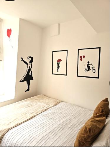 a bedroom with a bed and some pictures on the wall at Sidemersey Livings - Spacious Loft for bigger groups - Very Central and Cosy in Liverpool
