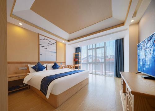 a bedroom with a bed and a flat screen tv at Zhangjiajie DreamWay Hotel - Free pick up service in Zhangjiajie