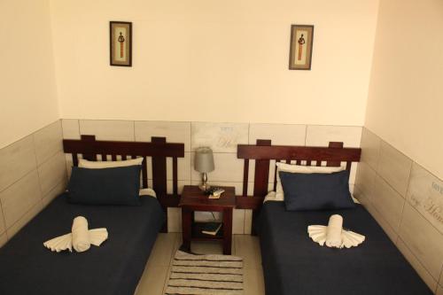 a room with two beds with pillows on them at Esperanca Guesthouse in Windhoek