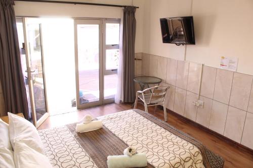 a room with a couch and a table and a chair at Esperanca Guesthouse in Windhoek