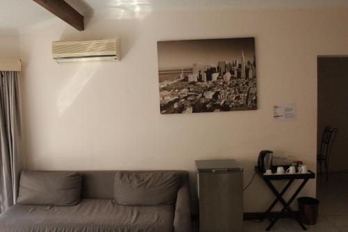 a living room with a couch and a picture on the wall at Esperanca Guesthouse in Windhoek
