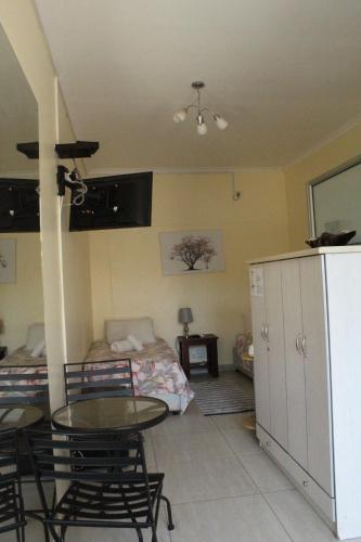 a living room with a table and a bed at Esperanca Guesthouse in Windhoek
