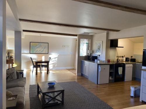 a kitchen and living room with a couch and a table at Red lion little barn in Ipswich