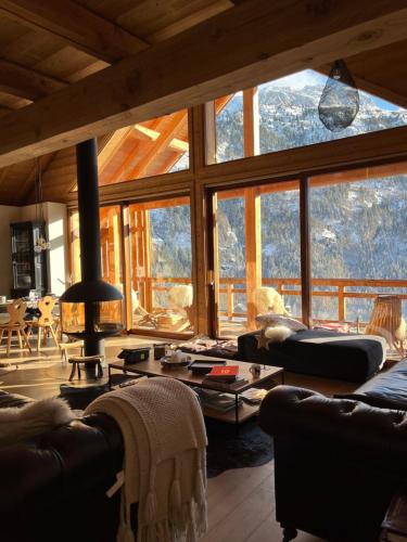 - un salon avec des canapés et une grande fenêtre dans l'établissement Luxurious Chalet Apartments - Chalet Serendipité, à Vaujany