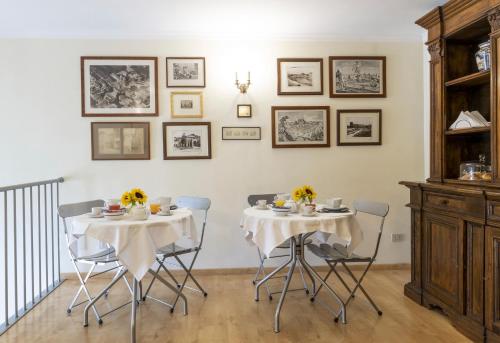 a dining room with two tables and chairs with flowers on them at Hotel Scalinata Di Spagna in Rome
