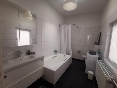 une salle de bain avec une baignoire, un lavabo et des toilettes dans l'établissement Stadtappartement Miltenberg Perle am Main, à Miltenberg