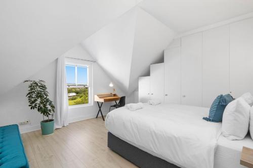 Un dormitorio blanco con una cama grande y una ventana. en Summerville Beach Loft by Host Agents, en Ciudad del Cabo
