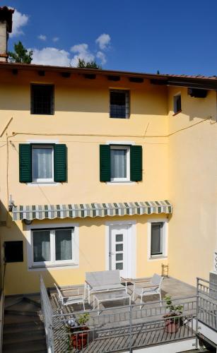 a yellow building with tables and chairs on a balcony at Casa di Anna - Relax in un paesaggio suggestivo in Cormòns