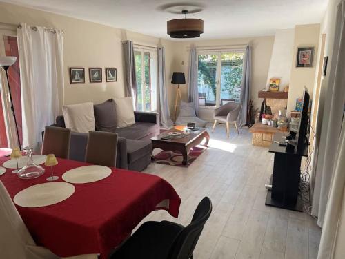 a living room with a red table and a couch at Maison vacances Biarritz sud - plages à pied in Bidart