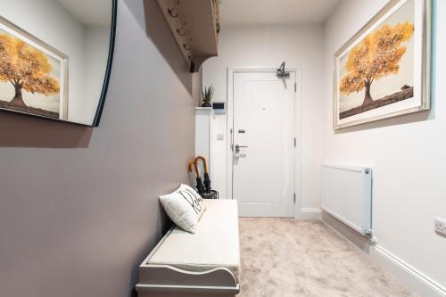 a living room with a white couch and paintings on the wall at Manor House Apartment in Bournemouth