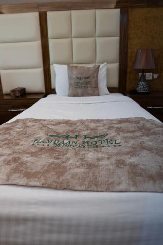 a bed in a hotel room with a white bedspread at HAMDAAN Hotel in Hargeysa