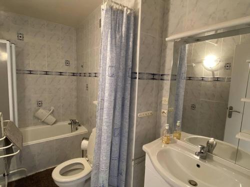 a bathroom with a toilet and a tub and a sink at Appartement T2 avec balcon, cuisine équipée, parking - FR-1-593-28 in Les Angles