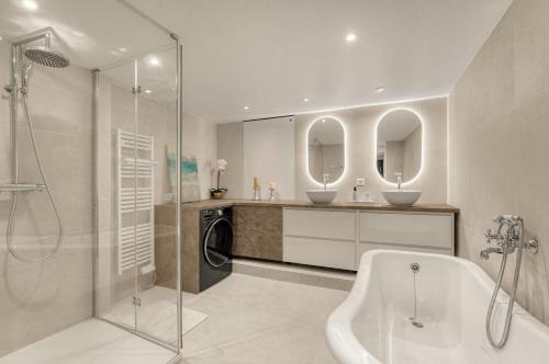 une salle de bain avec baignoire et machine à laver dans l'établissement L'Epicurus - À 5 min du Capitole, à Toulouse