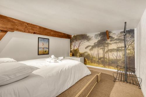 une chambre avec un lit blanc et un tableau au mur dans l'établissement L'Epicurus - À 5 min du Capitole, à Toulouse