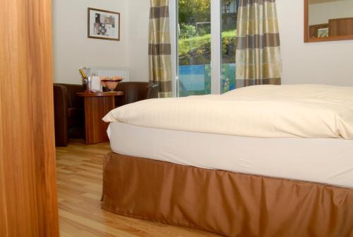 a bed sitting in a room with a window at Hotel-Restaurant Laux in Merzig