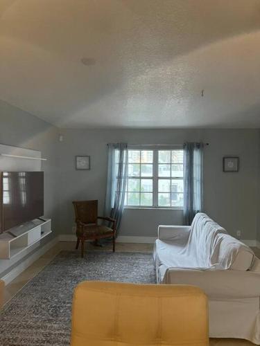 a living room with a couch and a tv at Hollywood Townhouse steps to beach and famous Broadwalk in Hollywood Beach